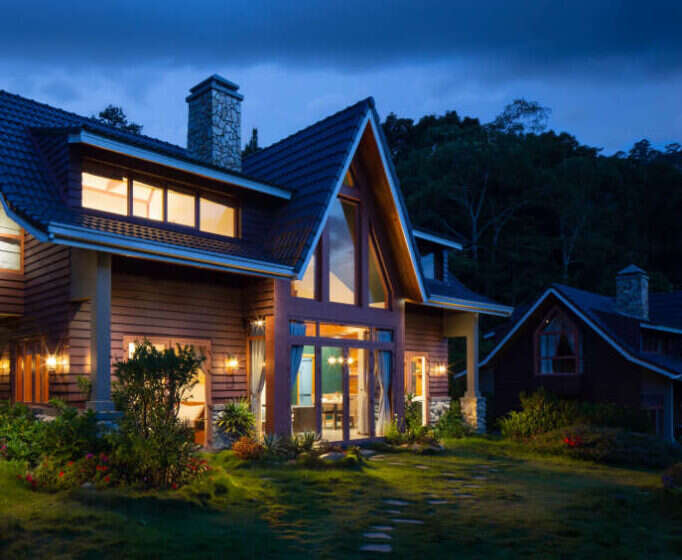 Timber house with lit windows at dusk