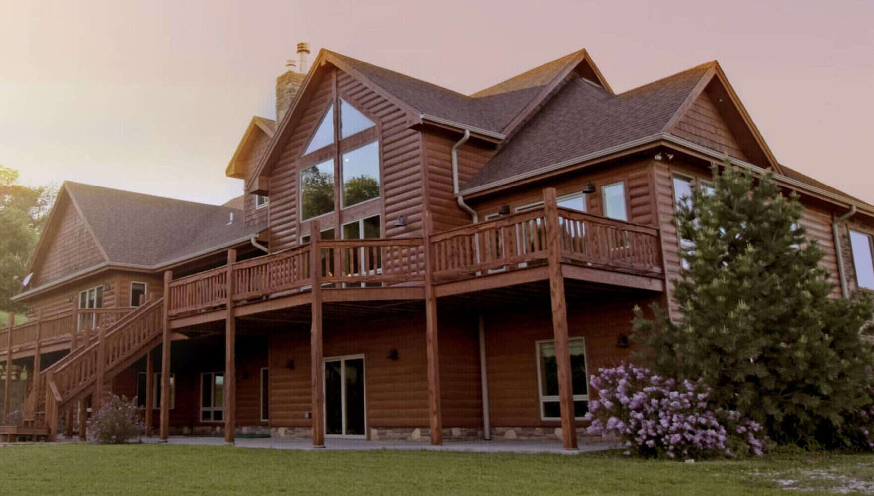 Wooden house with a large deck at sunset