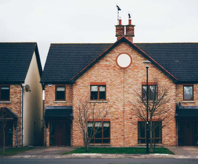 Red brick house with a round window and chimneys