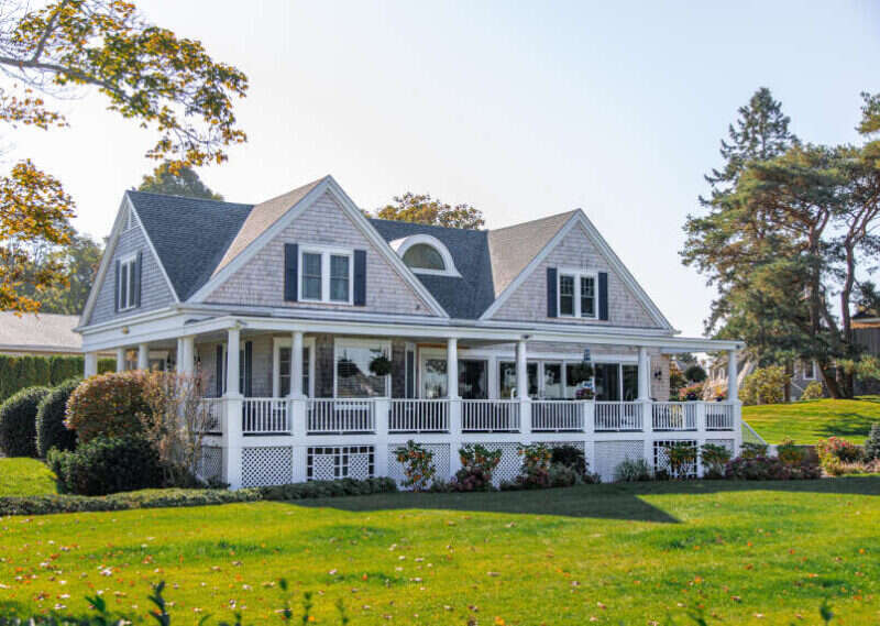 White shingle house with a wraparound porch