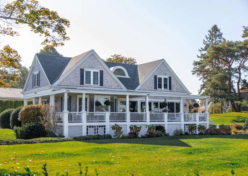 White shingle house with a wraparound porch