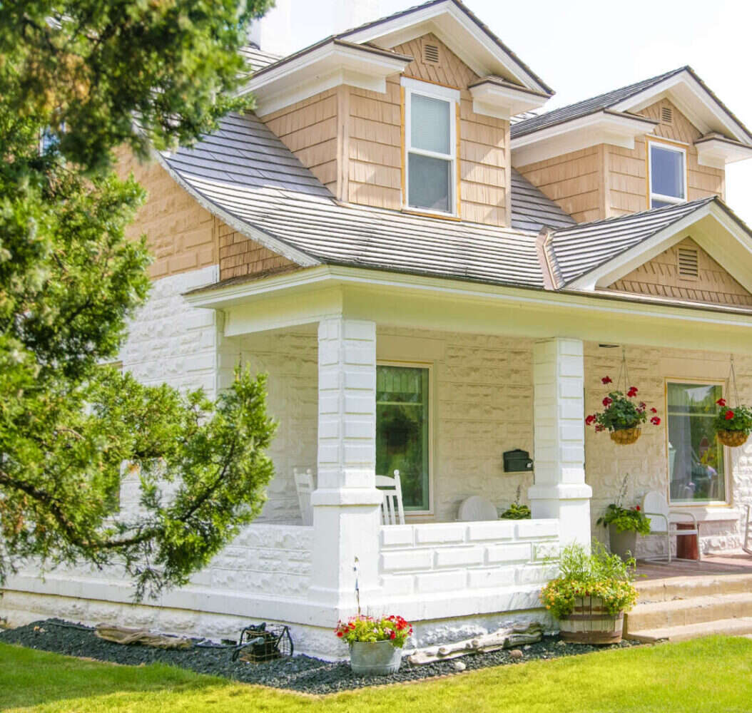 House with white siding and green trees